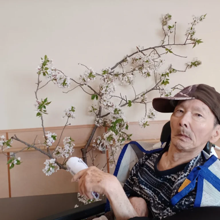 入居者が白い花の生け花作品を鑑賞・制作している様子